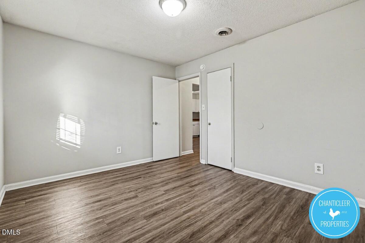 115 Florence Street, Unit 19 Graham, NC 27253 - Photo 12 of 29 a view of an empty room with wooden floor and a window