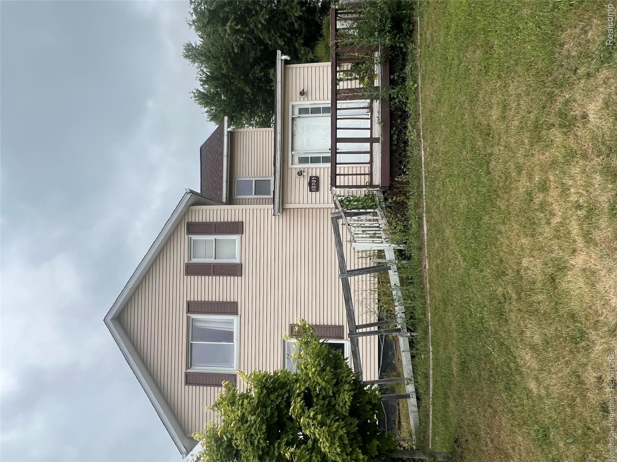 10305 Willis Road Willis, MI 48191 - Photo 1 of 1 Two-story residence with light-toned siding and dark shutters