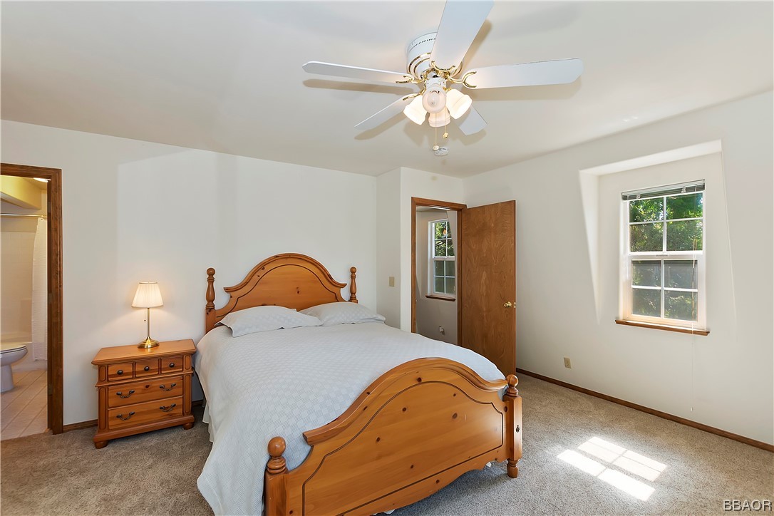 189 Pine Ridge Road Crestline, CA 92325 - Photo 15 of 30 a bedroom with a bed and a chandelier