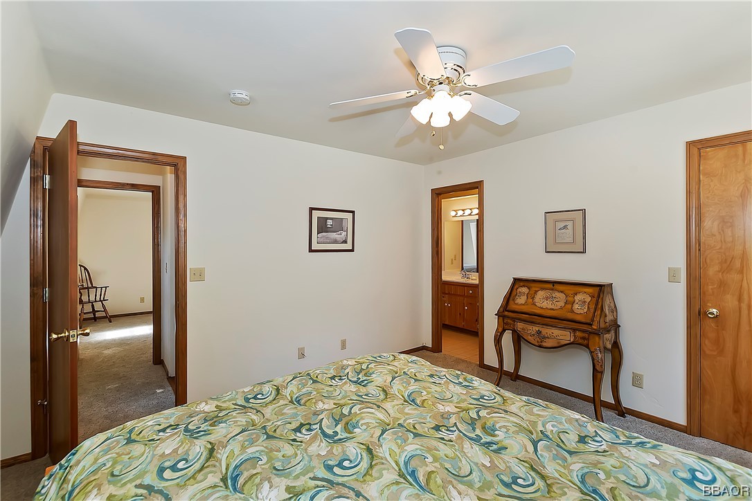 189 Pine Ridge Road Crestline, CA 92325 - Photo 19 of 30 a bedroom with a bed and a chandelier