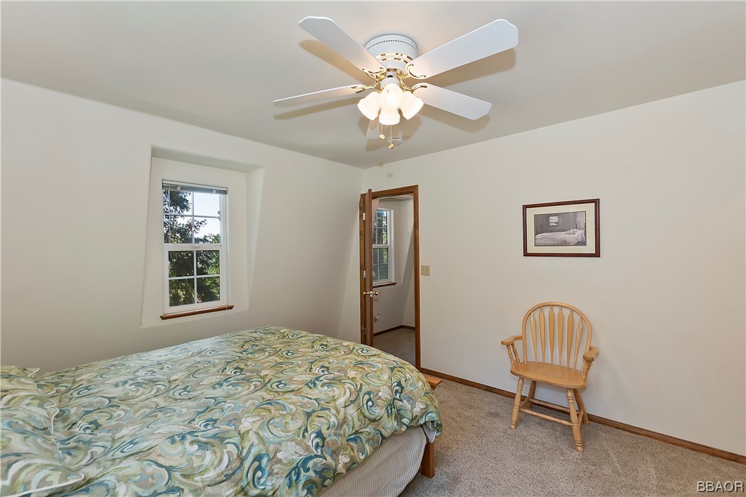 189 Pine Ridge Road Crestline, CA 92325 - Photo 20 of 30 a bedroom with a bed and a chandelier