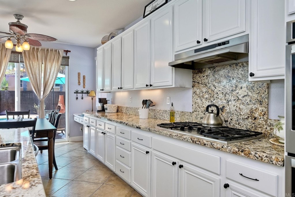 1738 Star Crest Place San Marcos, CA 92078 - Photo 19 of 51 a kitchen with stainless steel appliances granite countertop a stove a sink and a white cabinets