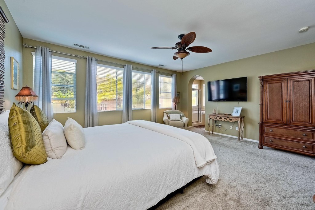 1738 Star Crest Place San Marcos, CA 92078 - Photo 27 of 51 a spacious bedroom with a bed flat screen tv and a large window