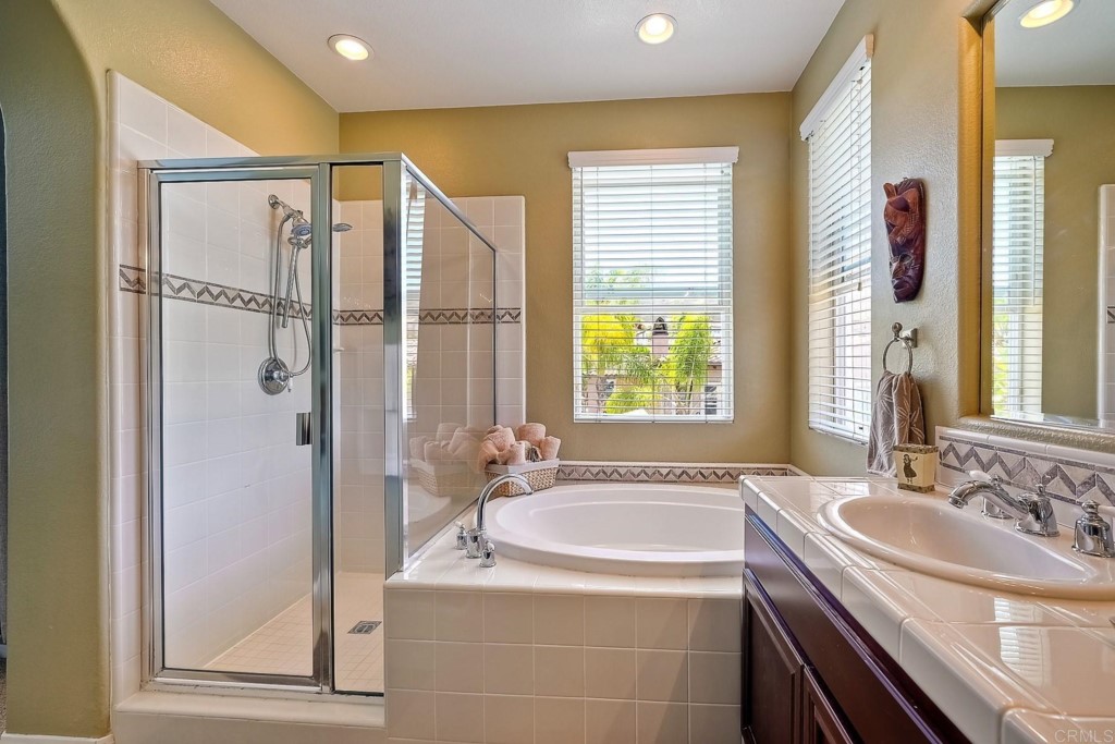 1738 Star Crest Place San Marcos, CA 92078 - Photo 31 of 51 a bathroom with a granite countertop sink a mirror a bathtub and next to a window