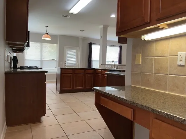 a kitchen with granite countertop a sink and a stove