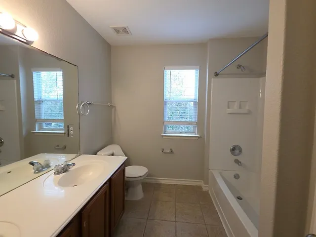 a bathroom with a double vanity sink mirror and shower