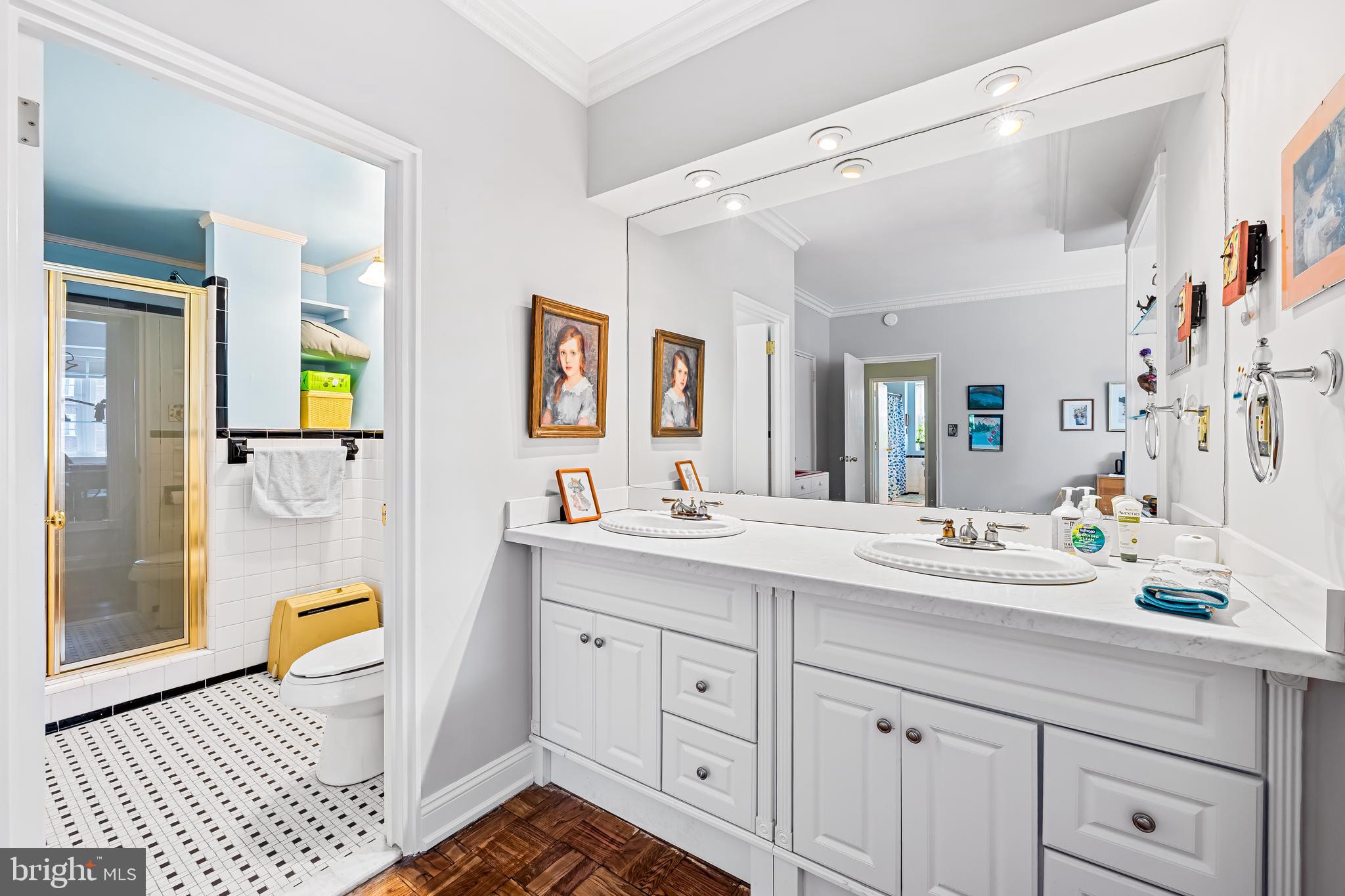 3601 Greenway, Unit 705 Baltimore, MD 21218 - Photo 21 of 30 a spacious bathroom with double vanity a toilet a mirror a vanity and a shower