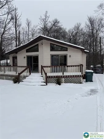 a view of a house with a wooden roof and wooden fence