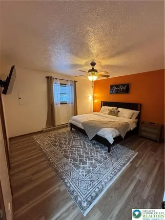 a bed sitting in a spacious bedroom next to a window