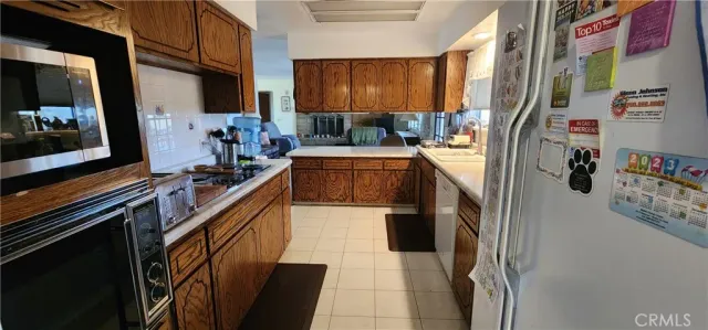 a kitchen with stainless steel appliances granite countertop a sink a stove and a refrigerator
