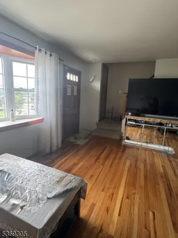 a bedroom with wooden floor and window