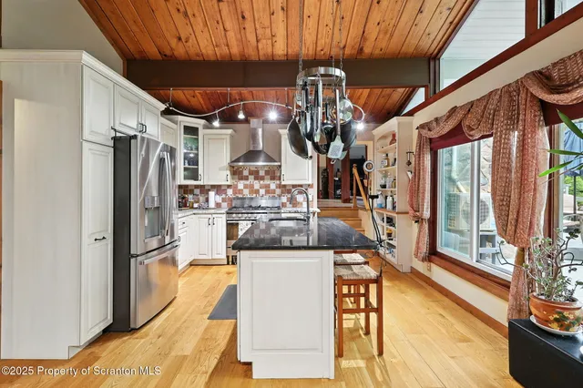 a kitchen with stainless steel appliances granite countertop a sink a stove and a refrigerator