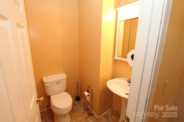 a bathroom with a granite countertop toilet and a sink