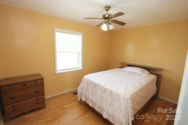 a bedroom with a bed a dresser and a window