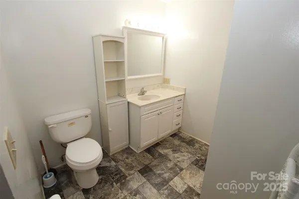 a bathroom with a toilet sink and mirror