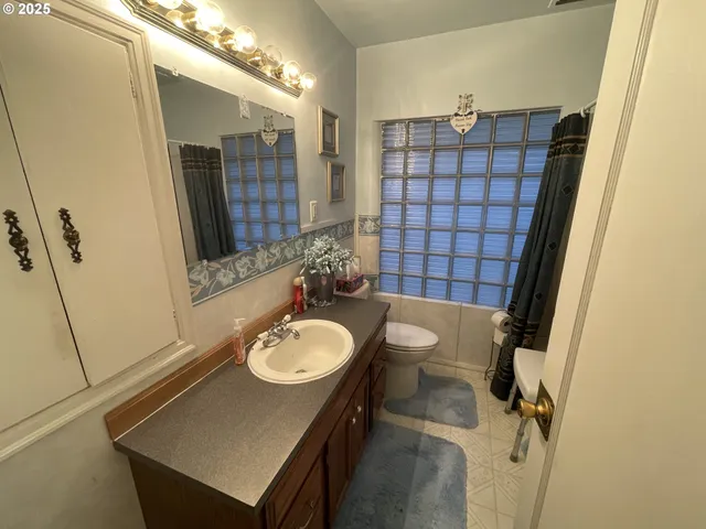 a bathroom with a sink vanity granite and a mirror