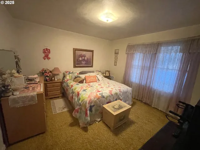 a bed sitting in a bedroom next to a window