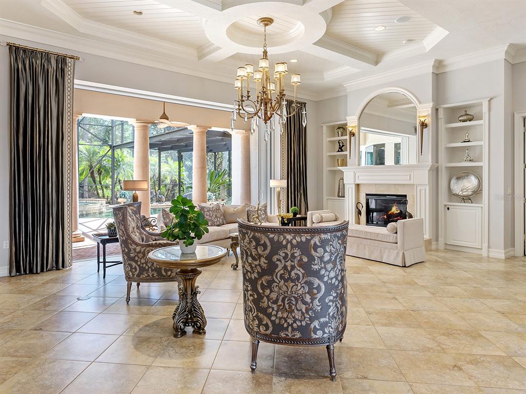 19428 Ganton Avenue Lakewood Ranch, FL 34202 - Photo 16 of 96 a living room with furniture a chandelier and a fireplace