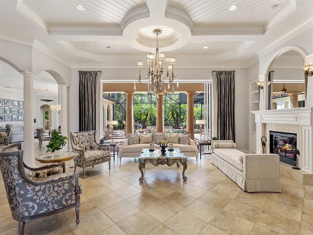 19428 Ganton Avenue Lakewood Ranch, FL 34202 - Photo 18 of 96 a living room with fireplace furniture and a chandelier
