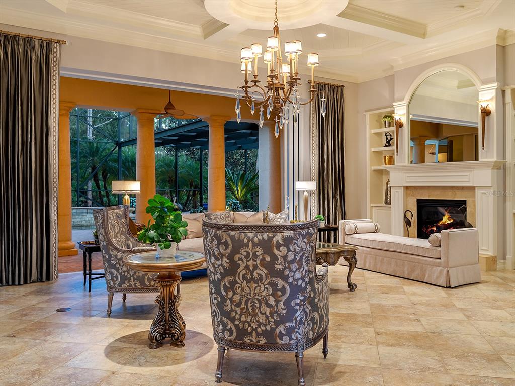 19428 Ganton Avenue Lakewood Ranch, FL 34202 - Photo 23 of 96 a living room with furniture a chandelier and a fireplace