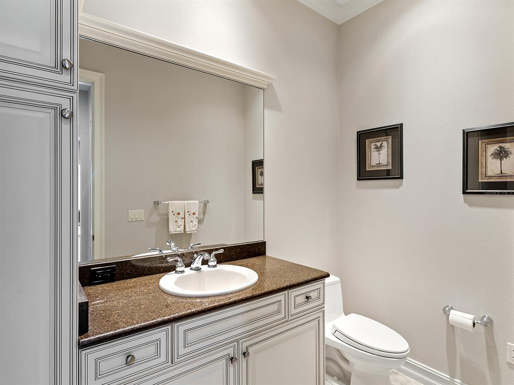 19428 Ganton Avenue Lakewood Ranch, FL 34202 - Photo 65 of 96 a bathroom with a granite countertop sink a toilet and a mirror