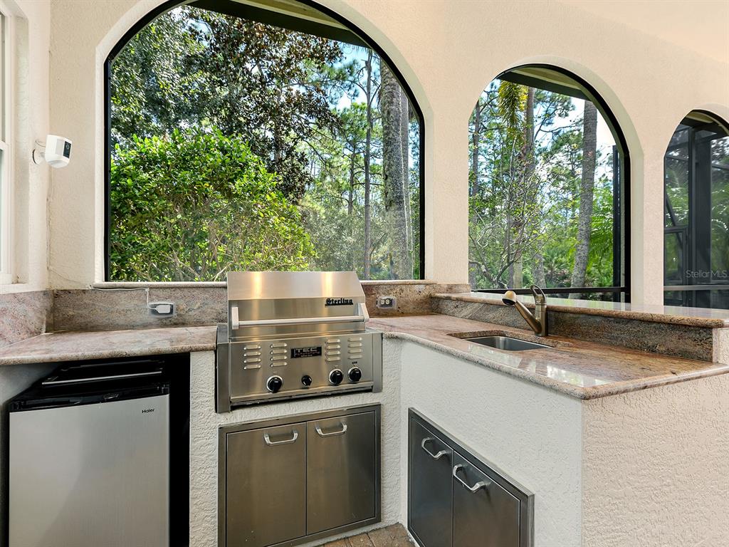 19428 Ganton Avenue Lakewood Ranch, FL 34202 - Photo 73 of 96 a kitchen with stainless steel appliances granite countertop a sink a stove and a wooden floor