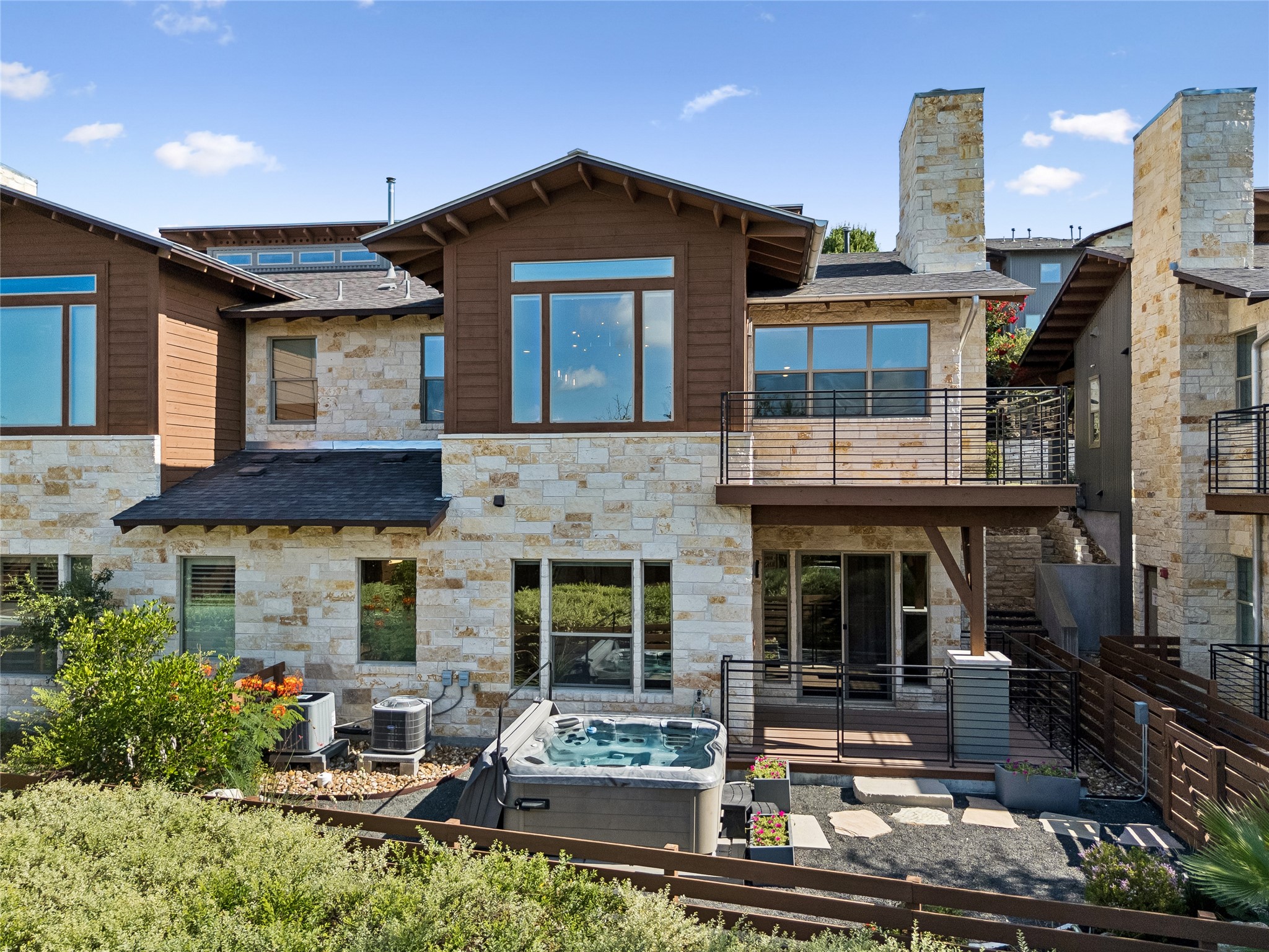 8110 Ranch Road 2222, Unit 68 Austin, TX 78730 - Photo 19 of 24 A spacious private patio and hot tub await at this modern, stone-clad residence.