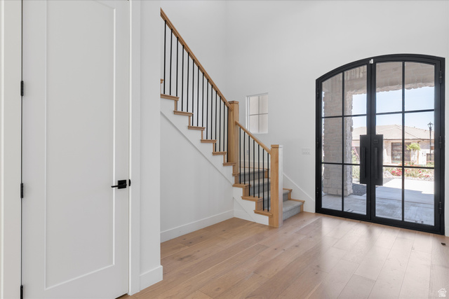 1192 East Corral Way Washington, UT 84780 - Photo 10 of 81 Grand entryway featuring light wood-finish flooring and a staircase with a wood handrail and black metal spindles
