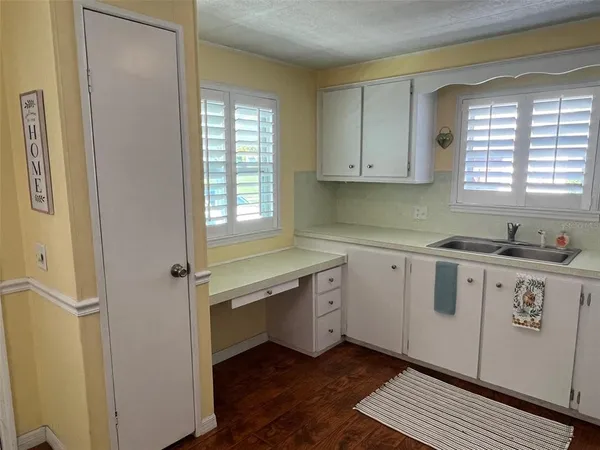 a kitchen with a white cabinets and wooden floor