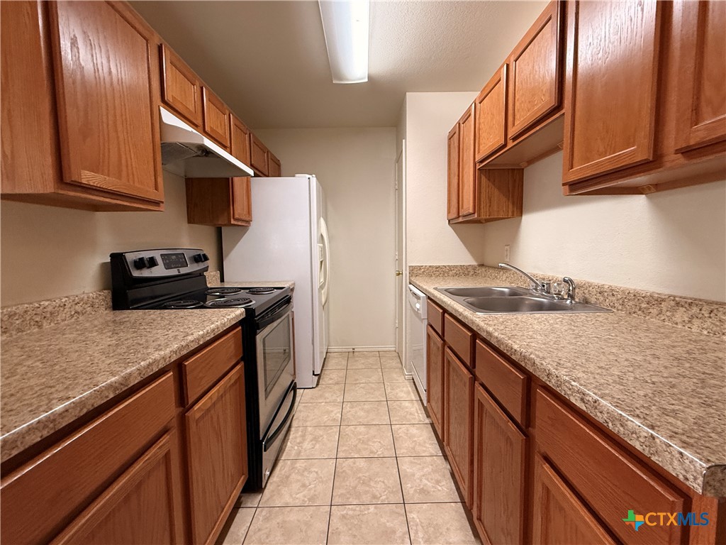 6210 Temora Loop, Unit B Killeen, TX 76549 - Photo 4 of 11 a kitchen with stainless steel appliances granite countertop a sink stove and cabinets
