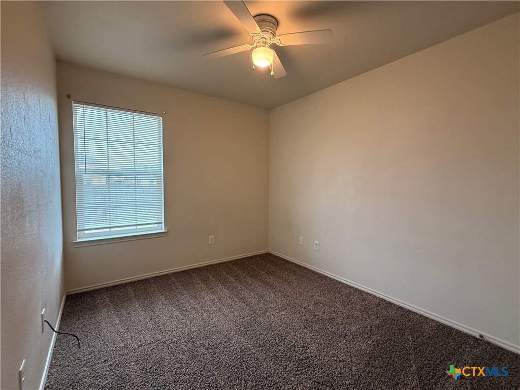 6210 Temora Loop, Unit B Killeen, TX 76549 - Photo 5 of 11 an empty room with a window and ceiling fan
