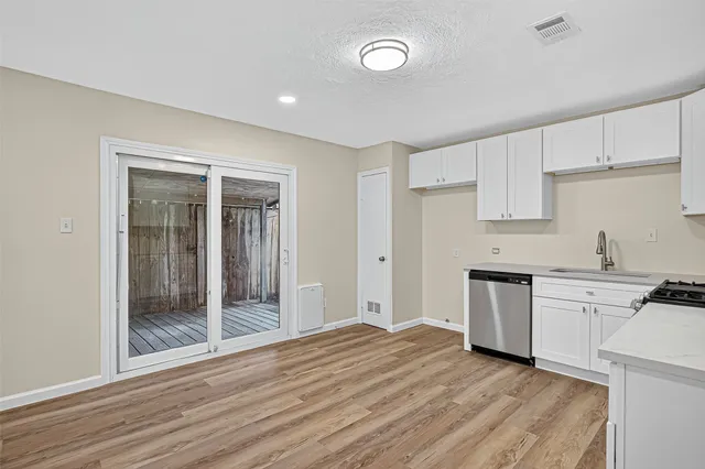 a view of a kitchen with a sink and dishwasher kitchen view with wooden floor