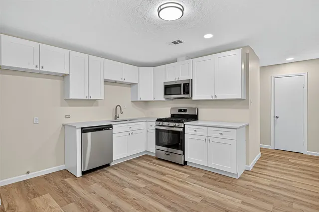 a kitchen with granite countertop white cabinets and appliances