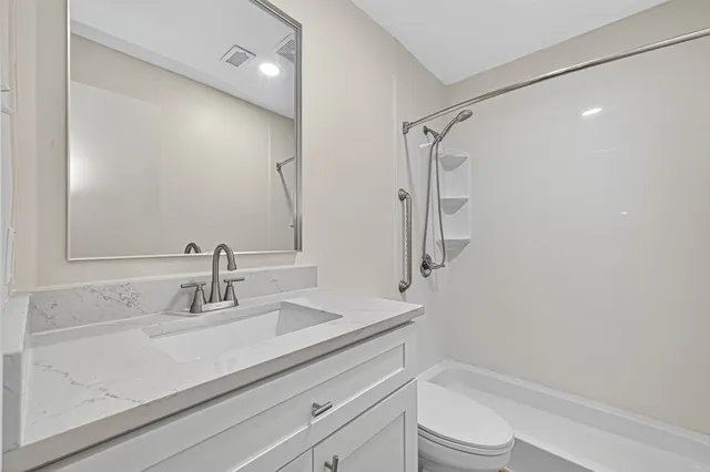 a bathroom with a sink a toilet and shower