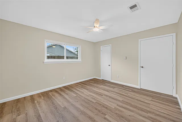 wooden floor in an empty room with a window