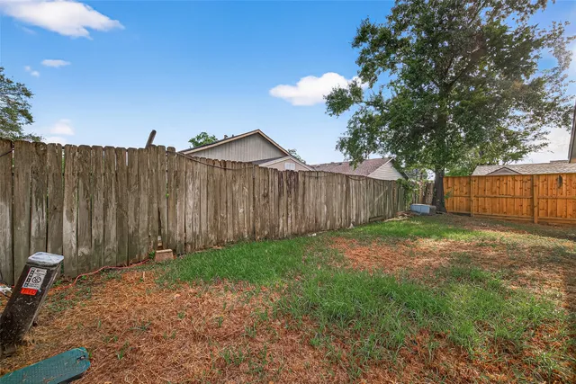 a view of a backyard with wooden fence