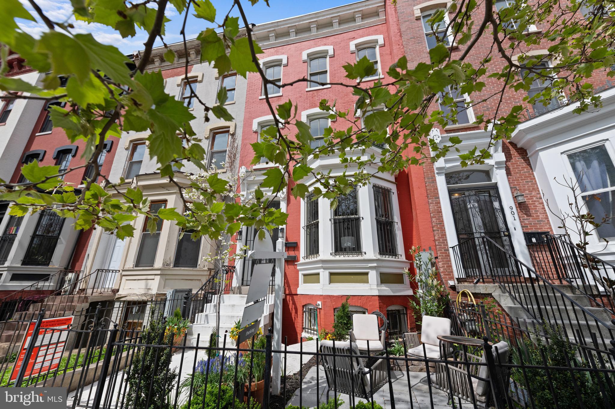 a front view of a multi story residential apartment building with yard and entryway