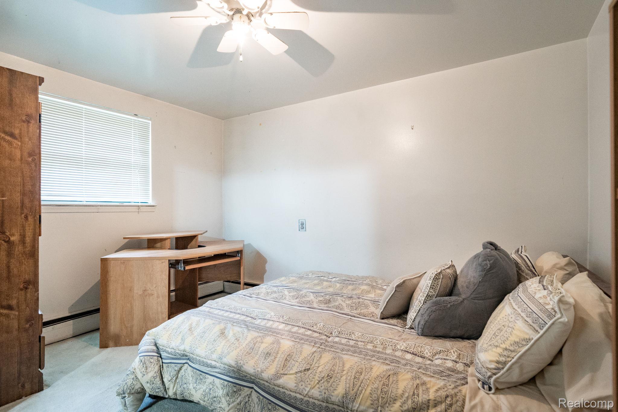 19650 Midway Road Southfield, MI 48075 - Photo 22 of 30 Bedroom featuring carpet, a baseboard heating unit, and ceiling fan