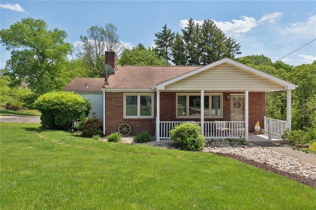 Welcome home to this level-entry brick ranch with covered front porch and mature landscaping.