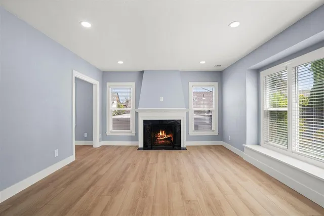 a view of an empty room with a fireplace and a window