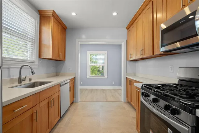 a kitchen with a sink stove top oven and cabinets
