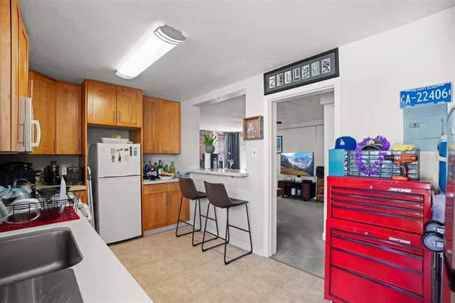 a kitchen view with furniture a refrigerator and a more cabinets