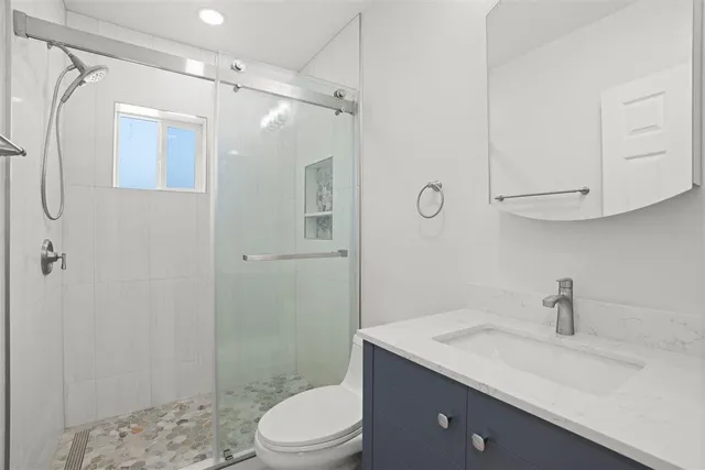 a bathroom with a sink a toilet and shower