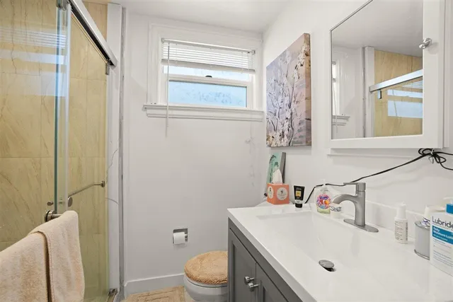 a bathroom with a sink a toilet and shower