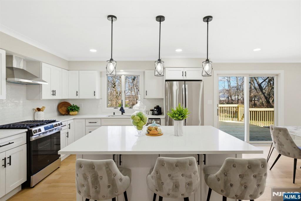 34 Knob Hill Road Morganville, NJ 07751 - Photo 16 of 50 a kitchen with stainless steel appliances granite countertop a stove a sink and white cabinets with wooden floors