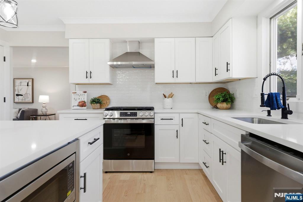 34 Knob Hill Road Morganville, NJ 07751 - Photo 18 of 50 a kitchen with white cabinets and appliances