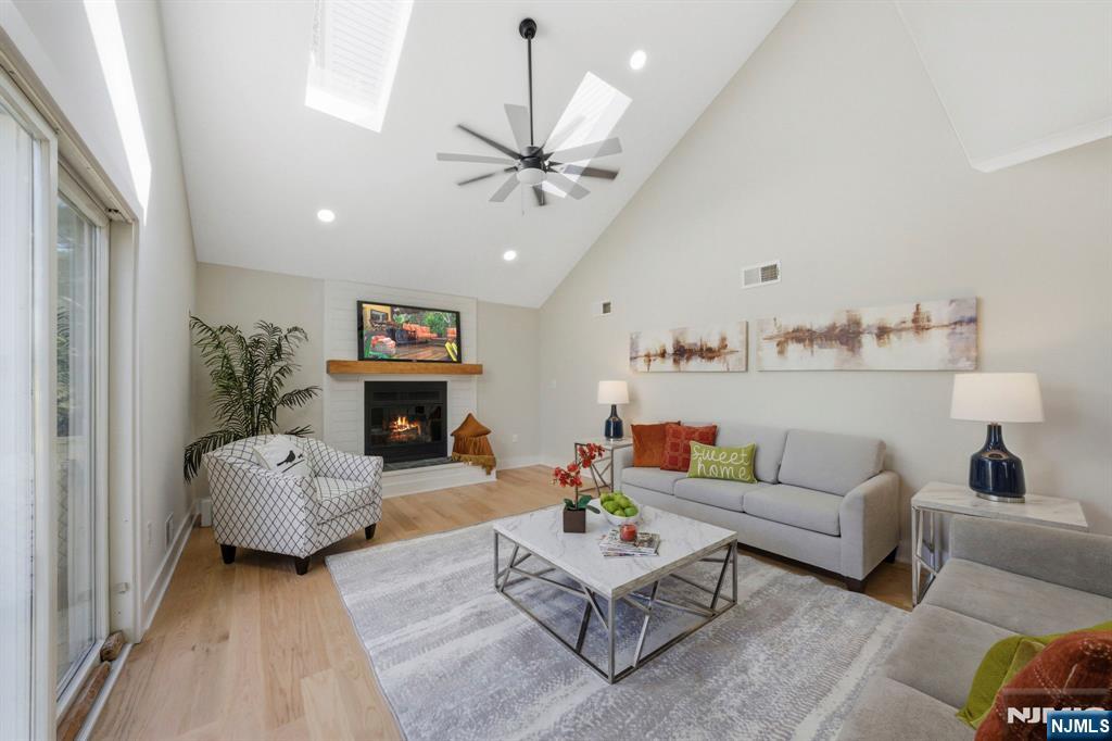34 Knob Hill Road Morganville, NJ 07751 - Photo 23 of 50 a living room with furniture a fireplace and a chandelier