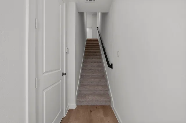 an empty room with chandelier fan and windows