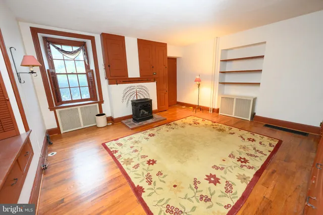 a view of an empty room with window and wooden floor