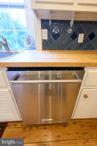 a bedroom with a bed and a flat tv screen on dresser